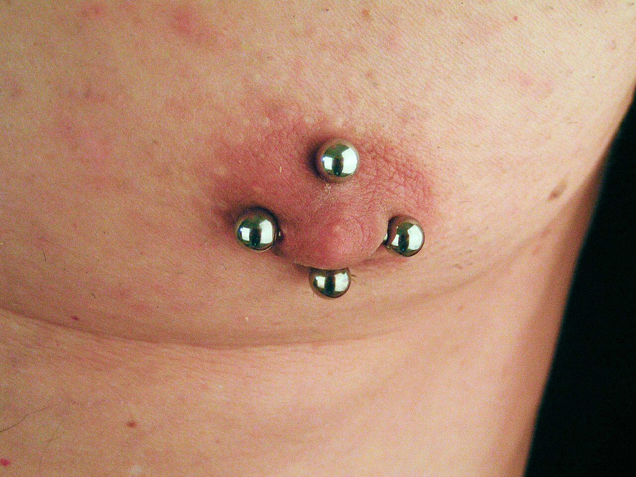 Piercings nipples in cross: a horizontal piercing, a vertical piercing. The jewels are bars of 1,6mm