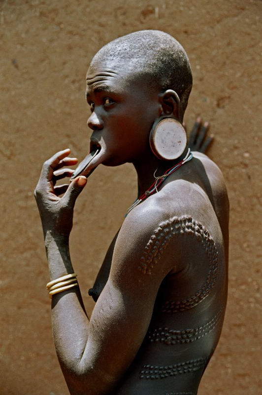 Mursi woman with typical scarification on her back and arms, Ethiopia, Africa