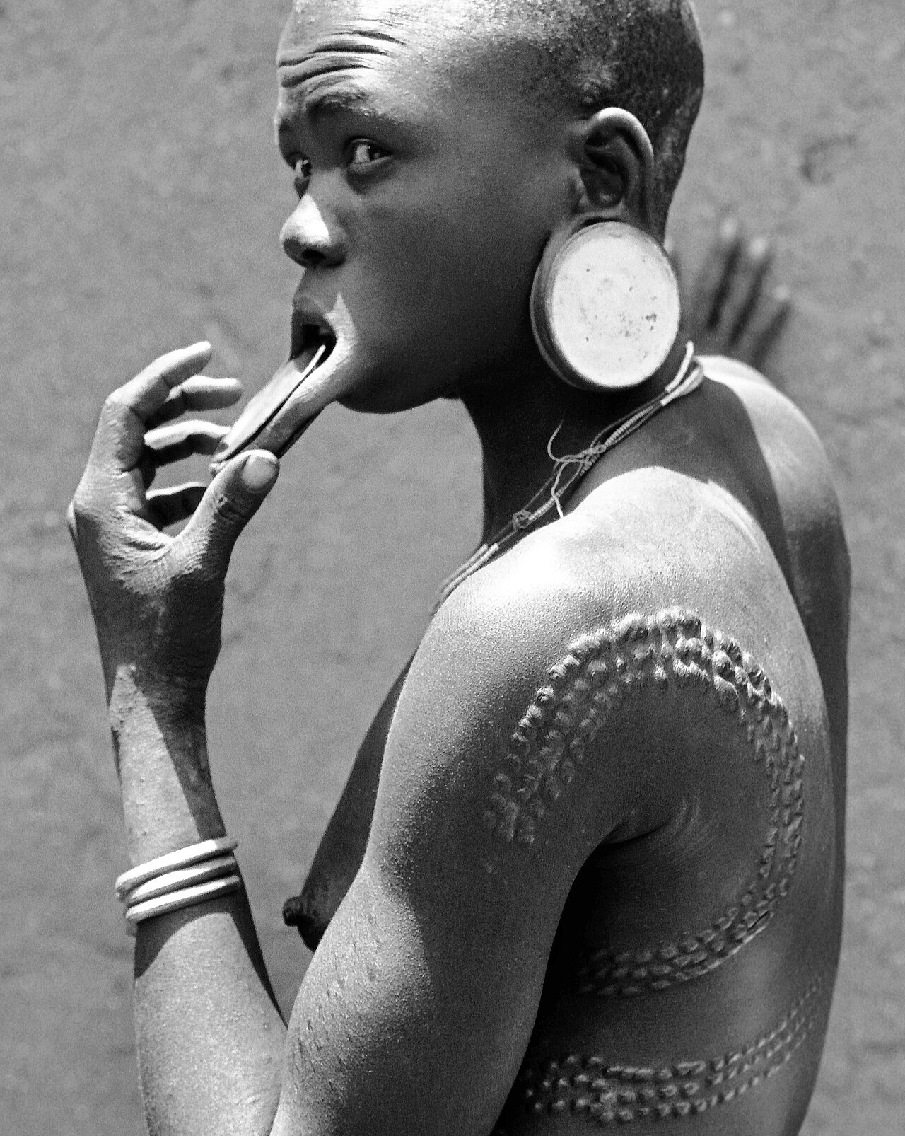Mursi woman with typical scarification on her back and arms, Ethiopia