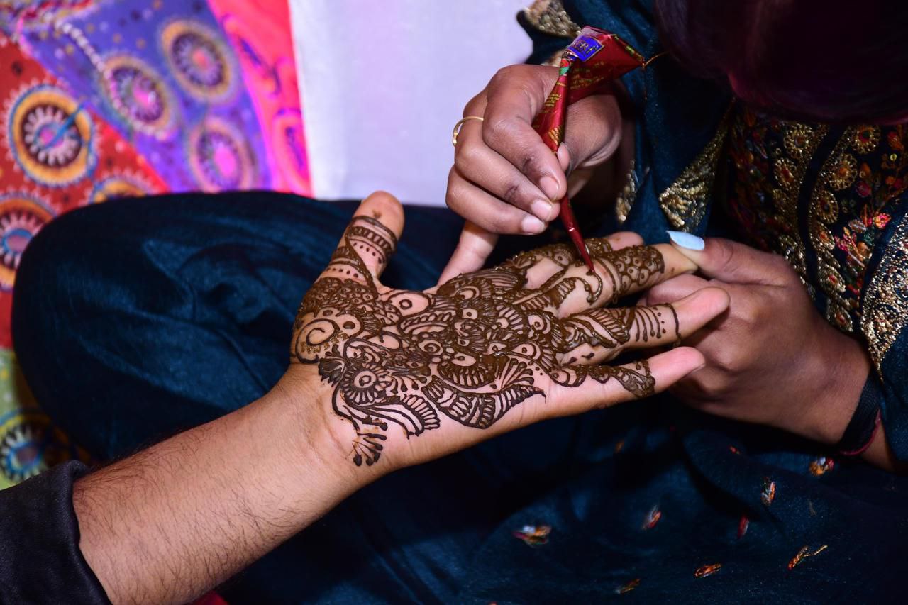 The groom's mehndi ceremony is a meaningful and beautiful celebration that signifies the start of his wedding festivities. As he sits, his hands embellished with detailed, rich henna designs, a feelin