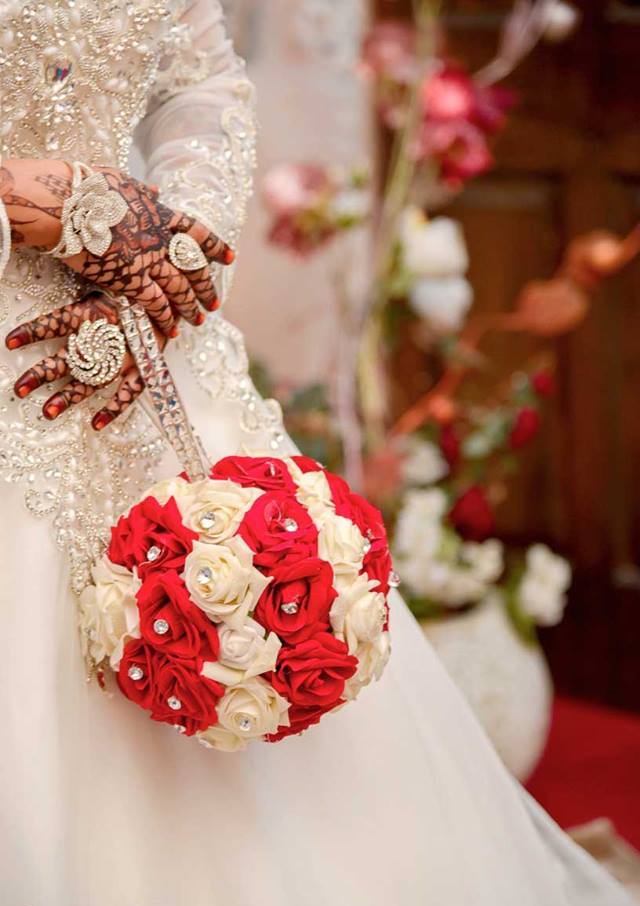 An Arab bride a basic, hand-tied rose bouquet, on her hands henna