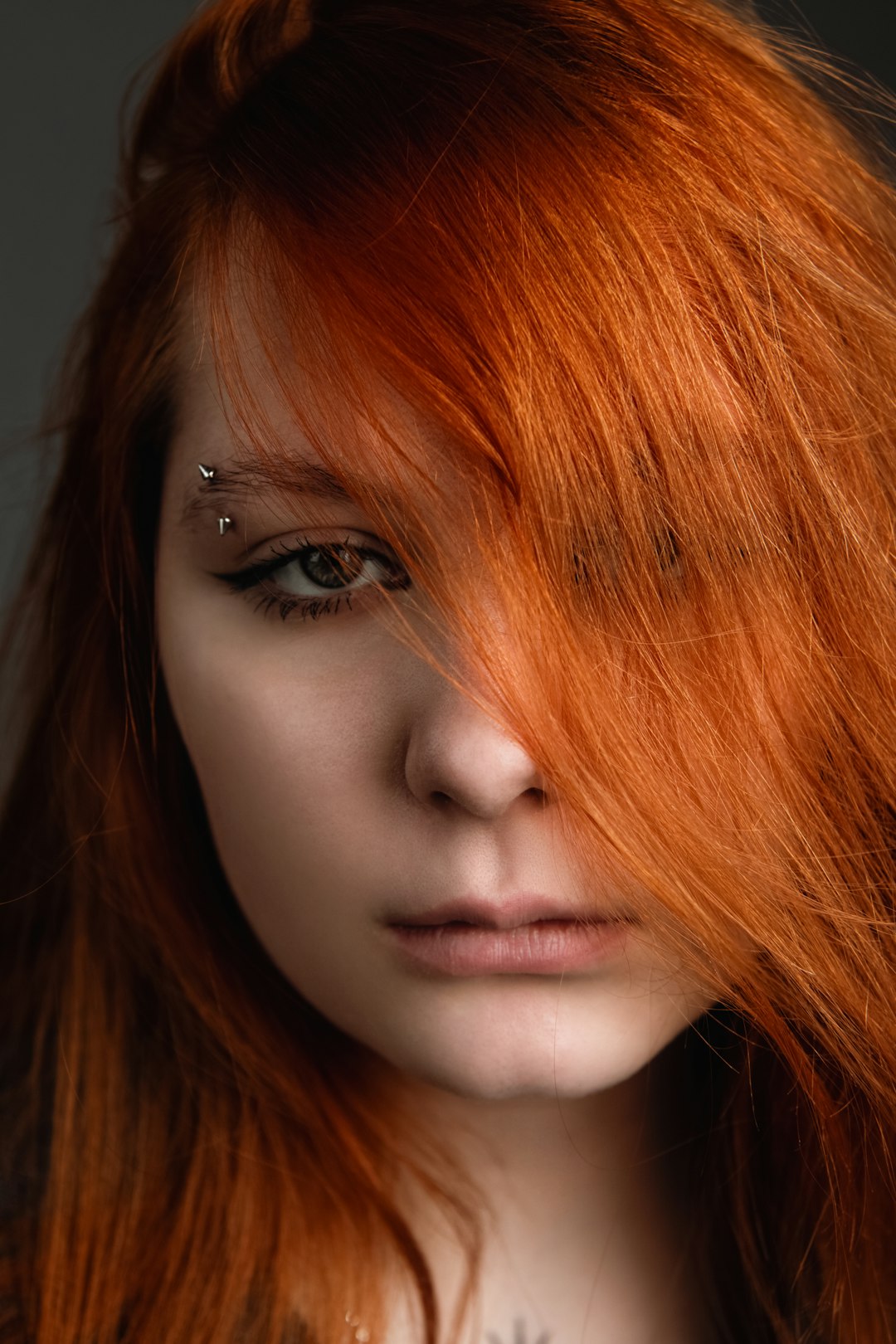 Red-haired girl with eyebrow piercings