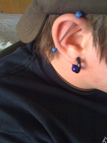 Image of an industrial piercing and a 6 gauge captive bead ring piercing.