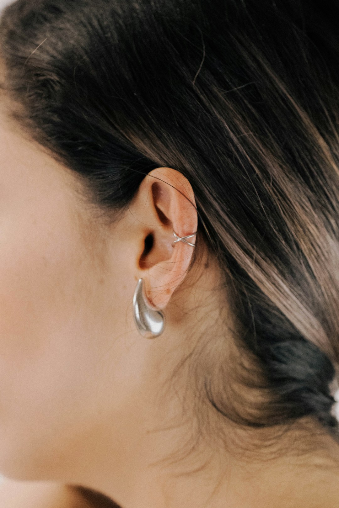 a close up of a person wearing a pair of earrings
