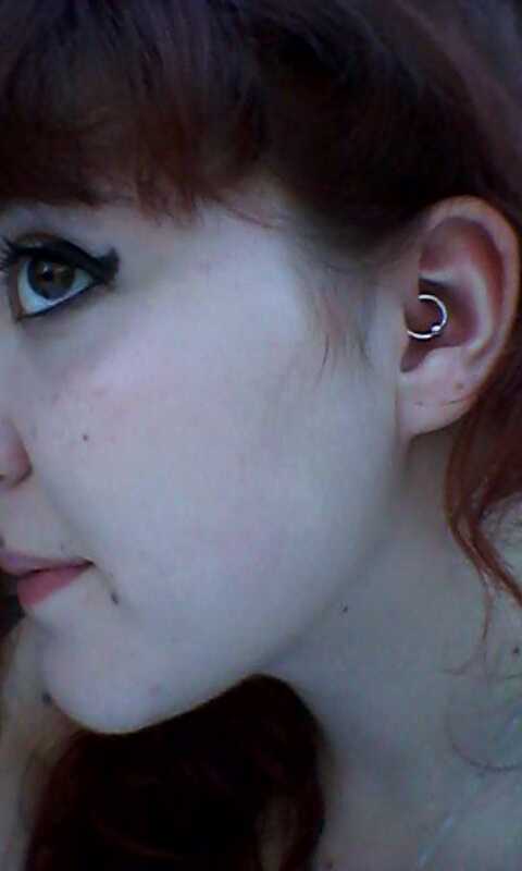 A Daith piercing, specifically a captive bead ring. The ring passes through the crus of the helix, a fold of cartilage in the ear.
