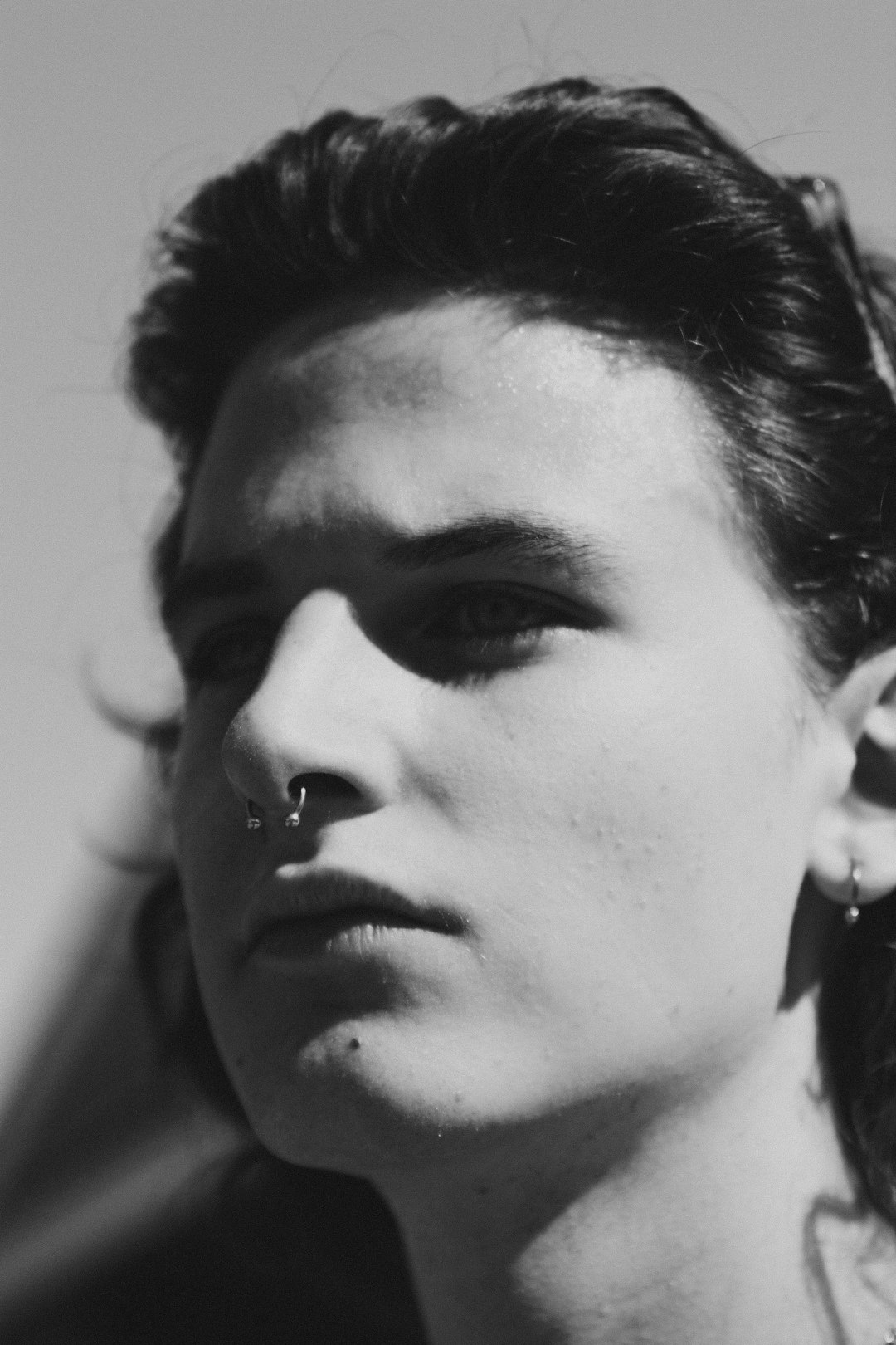 a black and white photo of a woman with a nose piercing