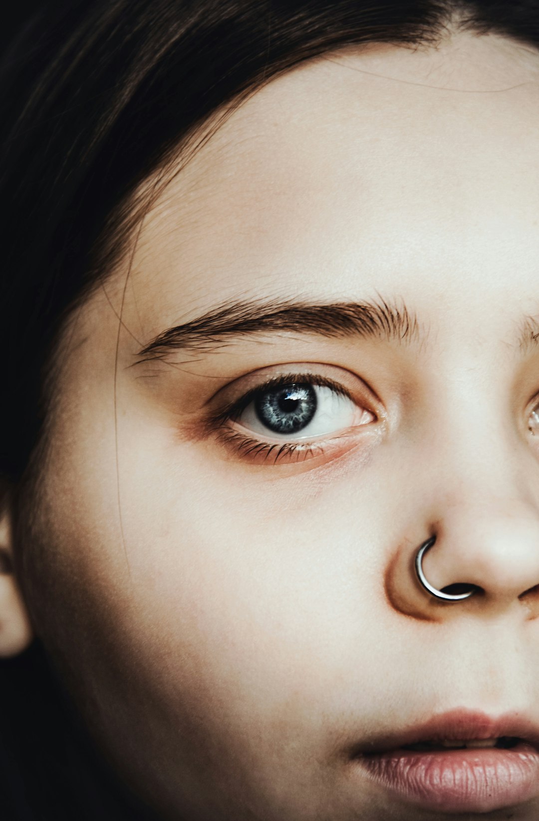 a girl with a nose ring and nose piercing