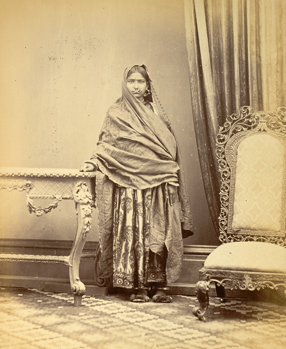 Full-length standing studio portrait of a Hindu girl from Karachi in Sind, Pakistan, taken by Michie and Company in c. 1870, from the Archaeological Survey of India Collections. This is one of a serie