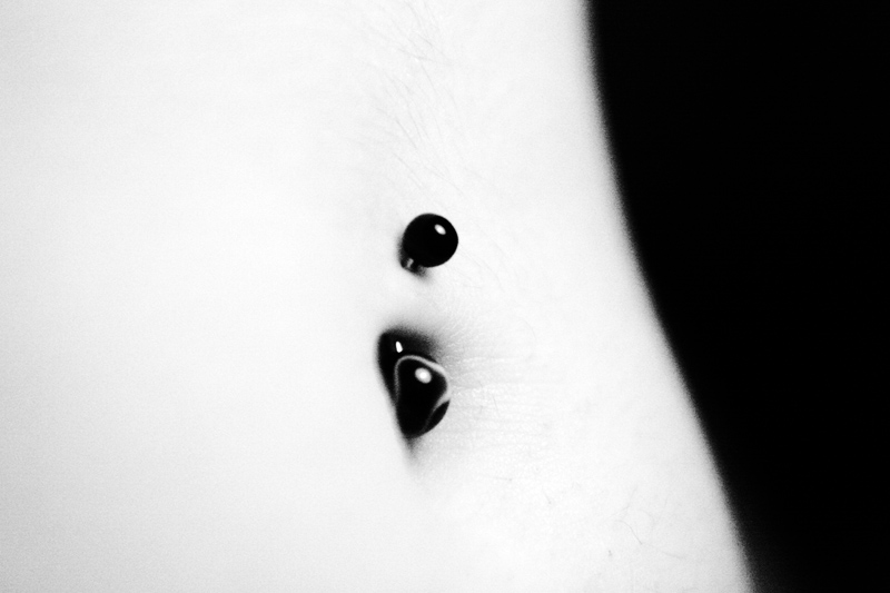 Female navel piercing in B&W.