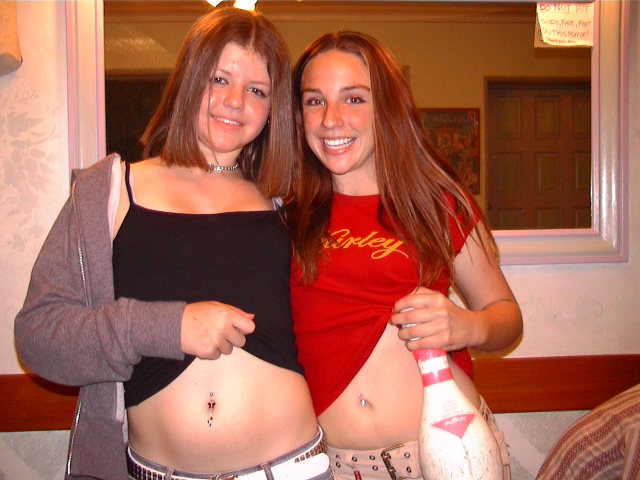 Two women show their pierced navels.