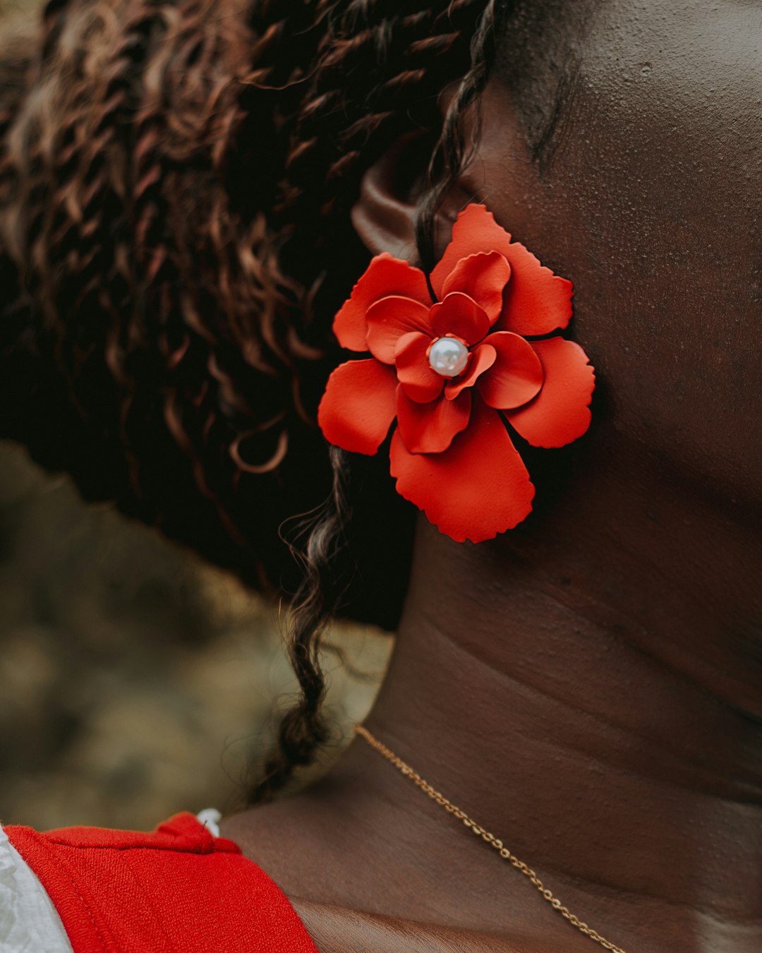 Woman wearing a large red flower earring