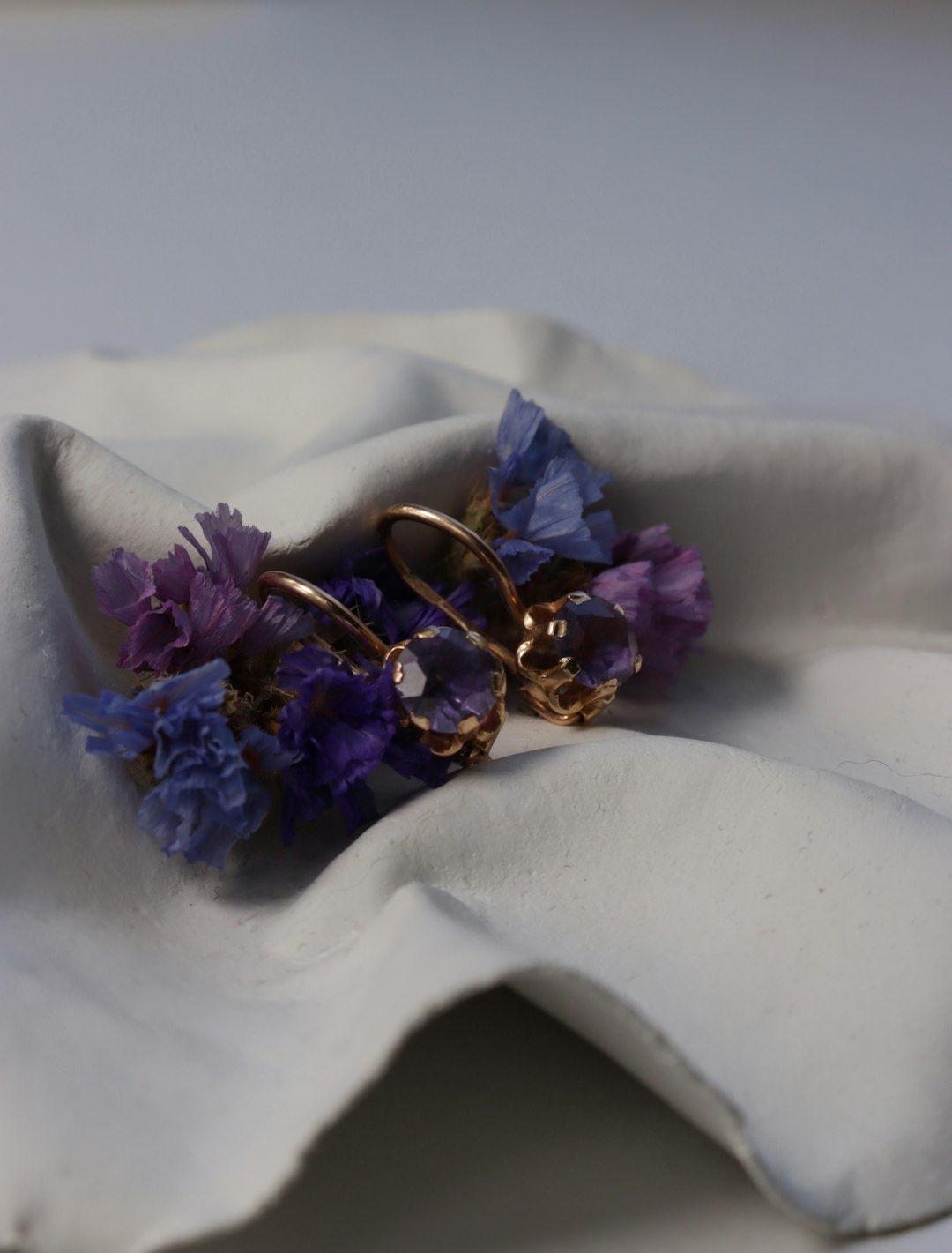 Earrings rest on a bed of flowers.