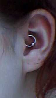 A Daith piercing, specifically a captive bead ring. The ring passes through the crus of the helix, a fold of cartilage in the ear.