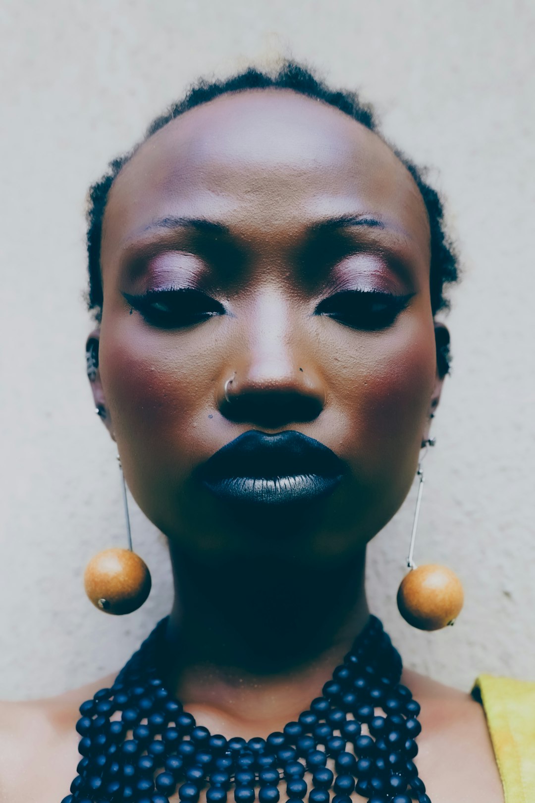 Woman with dark lipstick and large earrings