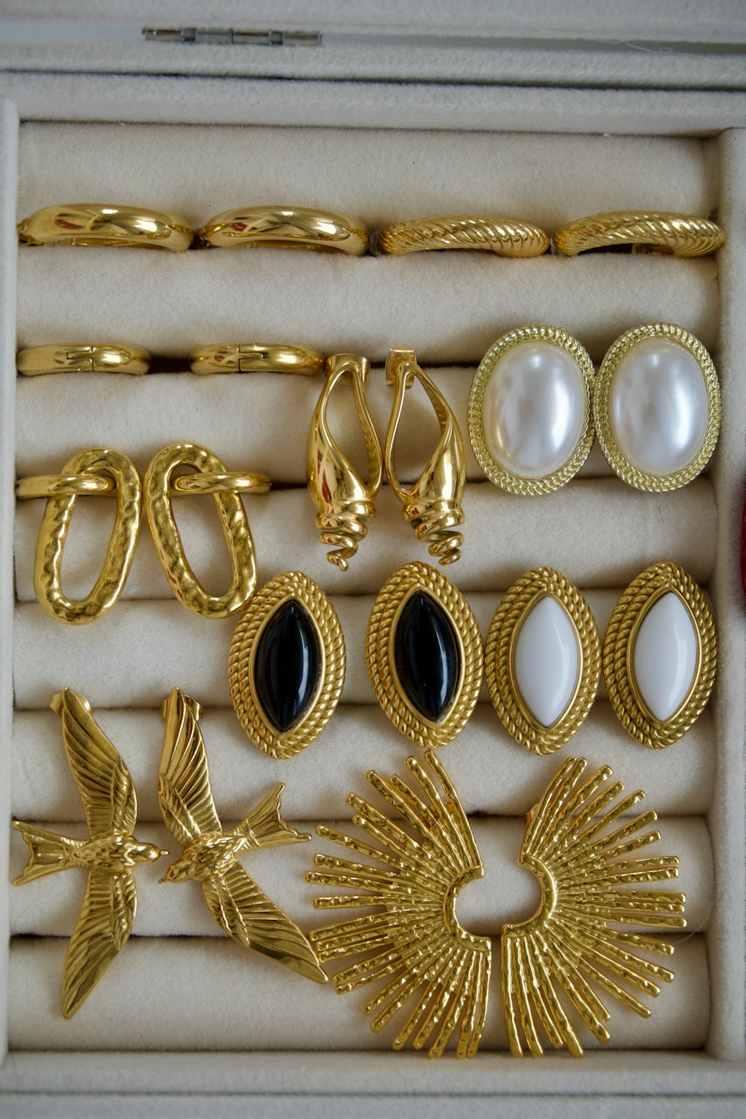 Collection of assorted gold earrings and jewelry in a box