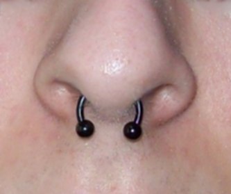 Ein Septum-Piercing mit schwarzem "Hufeisenring".