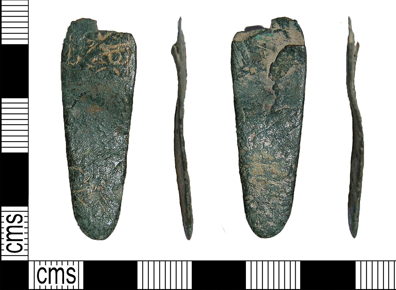An incomplete Early Medieval copper-alloy strap end dating to the mid eighth to mid tenth century AD. (AD 750 to 950).The strap end is tongue-shaped in plan with the remains of a bifurcated plate vis