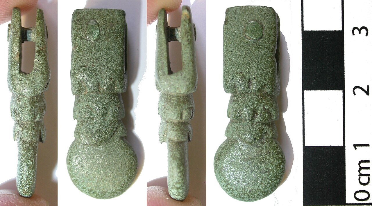 Early Medieval Viking period Anglo-Scandinavian cast copper alloy zoomorphic strap end. Attachment end bifurcated, forming short (length 14mm) rectangular undecorated plates, with a single copper allo