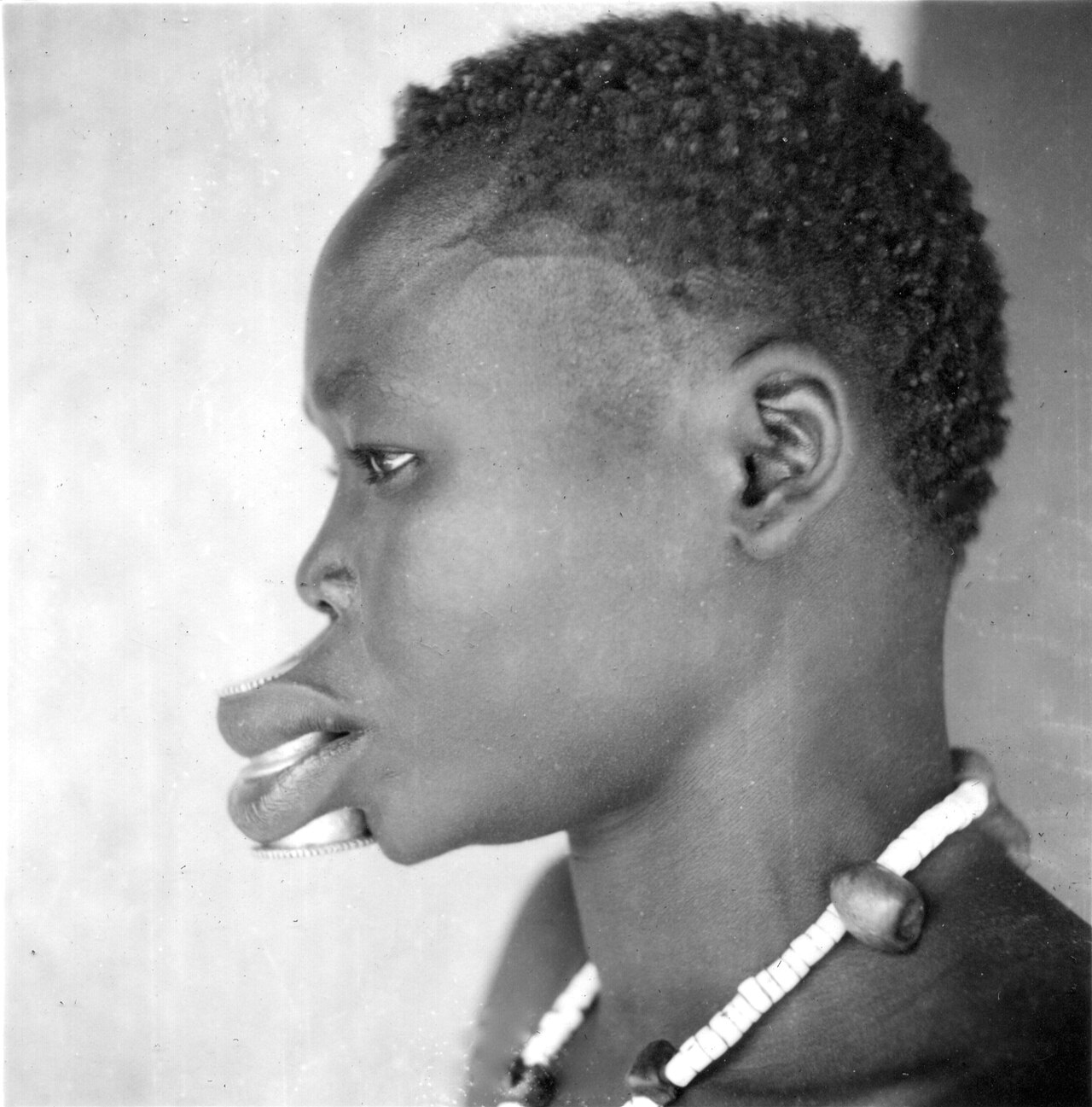 Woman with stretched labret piercings in Africa.