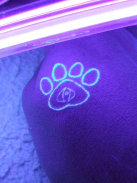 UV Tattoo on a hand illuminated under a blacklight.